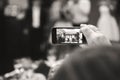 ODESSA, UKRAINE - MAY 30, 2015: Woman hand recording video with smartphone of people at the stage at the graduation party