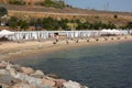 Odessa, Ukraine -2022: Metal military barriers, anti-tank hedgehogs on sea city beach. Vacationers sunbathe next to iron anti-tank