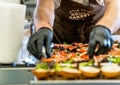 Odziena / Latvia - August 24th, 2018: Male Chef Putting Ingredients of Burgers in Black Gloves - Concept of the Hard Working