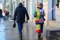 An off duty female street entertainer dressed as a clown walking