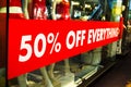 50% off everything sale red sign on shop front glass window. Royalty Free Stock Photo