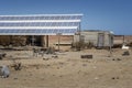 Off-grid solar installation in a messy trailer park in the desert