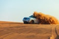 Off-road adventure with SUV in Arabian Desert at sunset. Offroad vehicle bashing through sand dunes in Dubai desert Royalty Free Stock Photo