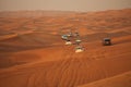 Off-road adventure with SUV driving in Arabian Desert at sunset. Offroad vehicle bashing through sand dunes in Dubai desert.