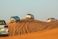 Off-road adventure with SUVs driving in Arabian Desert at sunset. Traditional entertainment for tourists with vehicle bashing thro Royalty Free Stock Photo