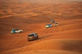 Off-road adventure with SUVs driving in Arabian Desert at sunset. Traditional entertainment for tourists with vehicle bashing thro Royalty Free Stock Photo