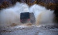 Off road. Four by four off road car crossing the lake with splashing water. Off road vehicle coming out of a mud hole Royalty Free Stock Photo