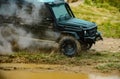 Off road jeep expedition to the villages on mountain road. Classic 4x4 car crossing water with splashes on muddy road