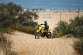 off-road motorcycle enduro motocross rider on sand dune, sea beach background