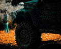 Off road sport truck between mountains landscape. Tracks on a muddy field. Bottom view to big offroad car wheel on Royalty Free Stock Photo