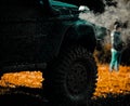 Off road sport truck between mountains landscape. Tracks on a muddy field. Bottom view to big offroad car wheel on Royalty Free Stock Photo