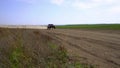 An off-road sports car rushes towards the finish line along a dusty field road at high speed