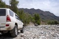 Off road suv moving on rocky bottom of dried river. Outdoor landscape. Adventure travel. Off road trail concept. Royalty Free Stock Photo