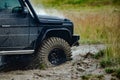 Off road vehicle coming out of a mud hole hazard. Water splash in off road racing. Motion the wheels tires and off-road Royalty Free Stock Photo