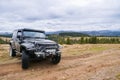 Black jeep parked in carpathians with picturesque mountain forests and clouds panorama