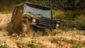 Off-road vehicle goes on the mountain. Bottom view to big offroad car wheel on country road and mountains backdrop Royalty Free Stock Photo