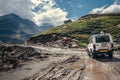 Off-road vehicle goes on the mountain way during the rainy season Royalty Free Stock Photo