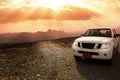 Off-road vehicle on the Jebel Shams mountains and cloudy sky with amazing sunrays Royalty Free Stock Photo