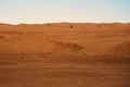 Off-road vehicle over desert dunes wahiba sands at sunset