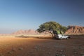 Off-road vehicle with roof tent on a sandy track in the sunset in the Naukluft Mountains in Namibia