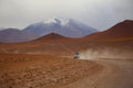 An off road vehicle running in the dusty of desert. Adventure in Bolivia highlands in the Andes. Royalty Free Stock Photo