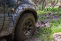 Off-road vehicle stuck in the mud. Dirty offroad car in swamp. Adventure travel concept. 4x4 SUV got bogged. Journey, tourism