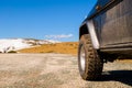 Off road 4x4 car in the snowy mountains on a sunny day. Off-road traveling, all terrain vehicle in nature Royalty Free Stock Photo