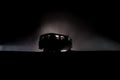 Off roader jeep silhouette on dark toned foggy sky background. Car with light at night