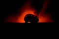 Off roader jeep silhouette on dark toned foggy sky background. Car with light at night Royalty Free Stock Photo