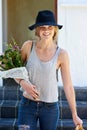 Off to surprise a friend with a picnic. A young woman walking down the stairs with a picnic basket and flowers. Royalty Free Stock Photo