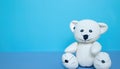 Offbeat teddy bear isolated on blue background with copy space