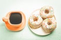 ÃÂÃÂ¡offee break. Orange cup with coffee and a plate from donats. Top view