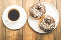 ÃÂ¡offee break. White cup with black coffee and donat in chocolate glaze. Wooden background, top view