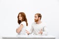 Offend redhead girl and redheand boy sitting at white desk