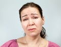 Offended adult Caucasian woman, portrait on grey background, emotions series