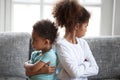 Offended African American siblings sitting turning away from eac