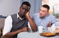 Offended African man with friend talking to him Royalty Free Stock Photo
