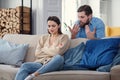 Offended angry woman sits on sofa at home after an argument with her husband. Broken marriage.