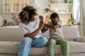 Offended black son boy pushes away mother who wants to reconcile due to misunderstanding of conflict