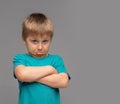 Offended boy in blue t-shirt. Sad and upset kid in studio. Childhood concept. Royalty Free Stock Photo