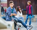 Offended boy and couple of teens apart on the street Royalty Free Stock Photo