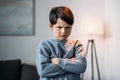 Offended boy with crossed arms looking at camera at home Royalty Free Stock Photo