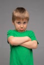 Offended boy in green t-shirt. Sad and upset kid in studio. Childhood concept. Royalty Free Stock Photo