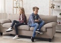 Offended Brother And Sister Sitting Back-To-Back On Sofa At Home Royalty Free Stock Photo