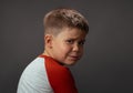 Offended child looks into the camera from behind his back. Crying boy in studio on an isolated background. High quality