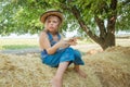 Offended child sits on a haystack Royalty Free Stock Photo