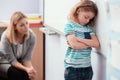 Offended child stands with his arms folded in the classroom Royalty Free Stock Photo