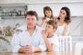 Offended father sitting at the kitchen table being hugged by son