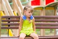Offended five year old girl sitting on bench and crying Royalty Free Stock Photo