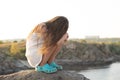 Offended five-year-old sad girl sitting on rocks in nature alone. Royalty Free Stock Photo
